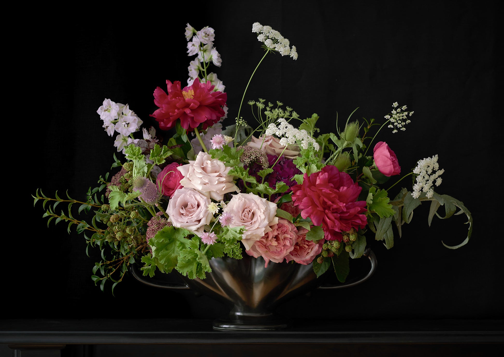 Limited Edition "Rose" Fine Art Photographic Print. Elegant Floral Arrangement of Roses and Peonies in a Antique Black Mantle Vase against a black background.